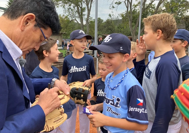 Trenér japonské baseballové reprezentace Hideki Kuriyama podepisuje baseballové rukavice mladým hráčům brněnského týmu Hroši.