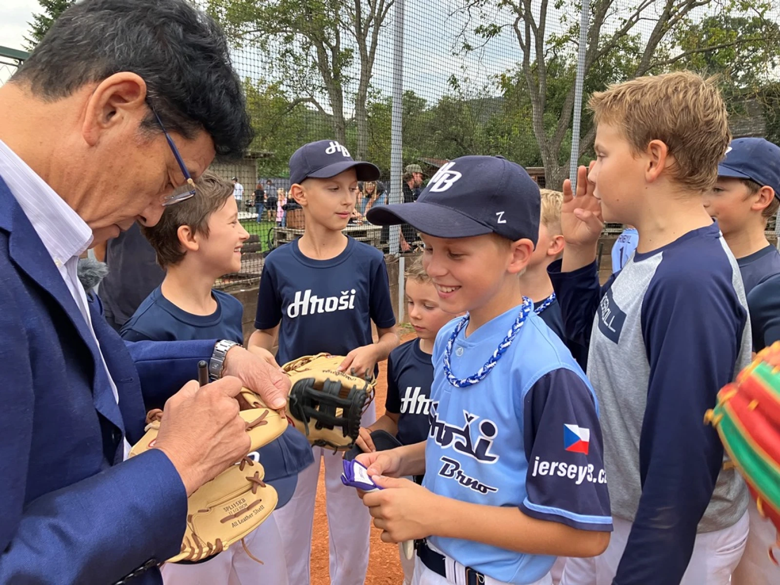 Trenér japonské národní baseballové reprezentace Hideki Kuriyama podepisuje mladým hráčům brněnského týmu Hroši baseballové rukavice.